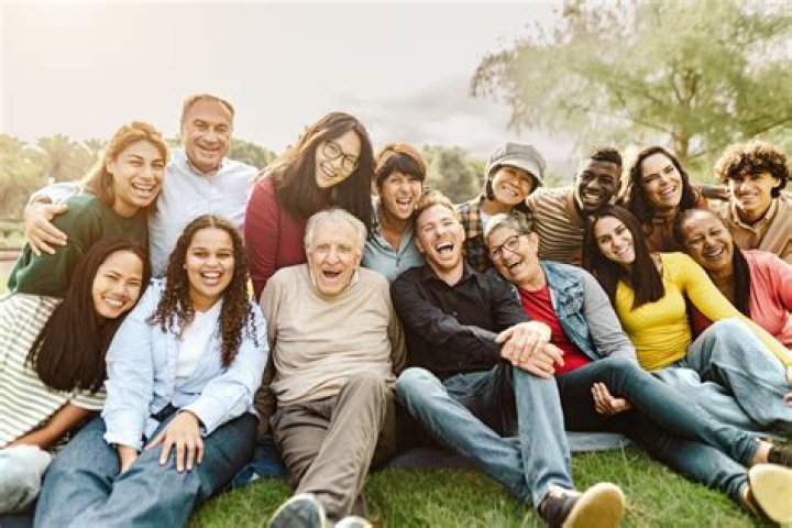 a group of people sitting next to each other on top of a couch in front